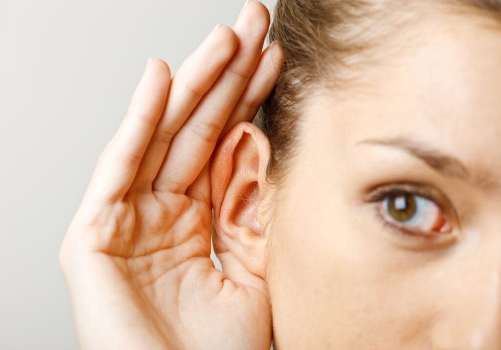 A woman with her hand by her ear